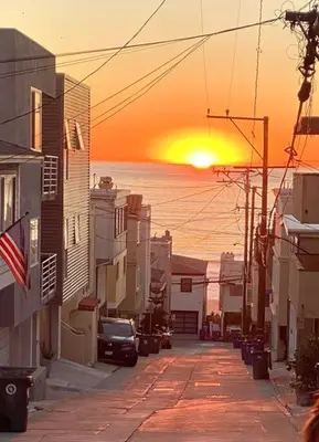 a city street with the sun setting in the distance at Beach Gateway Full Kitchen 1 Bedroom Duplex in Manhattan Beach