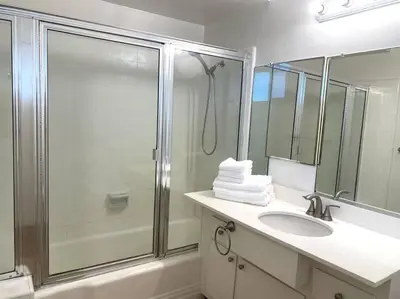 a bathroom with a shower and a sink and a mirror at Beach Gateway Full Kitchen 1 Bedroom Duplex in Manhattan Beach