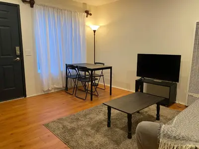 a living room with a table and a television at Beach Gateway Full Kitchen 1 Bedroom Duplex in Manhattan Beach