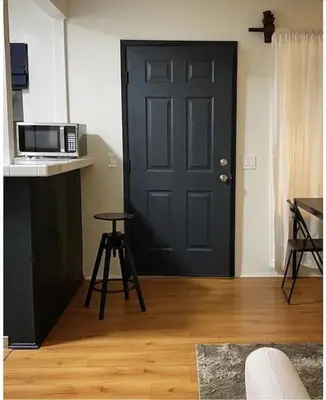 a black door in a room with a microwave at Beach Gateway Full Kitchen 1 Bedroom Duplex in Manhattan Beach