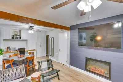 a living room with a fireplace and a dining room at Mid-Century Mod Cottage, Steps to Lake Gregory! in Crestline