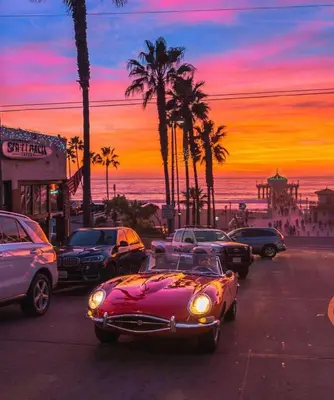 a pink car parked on a street with palm trees at NEW! Ocean View Mid-Century Modern Beach House in Manhattan Beach