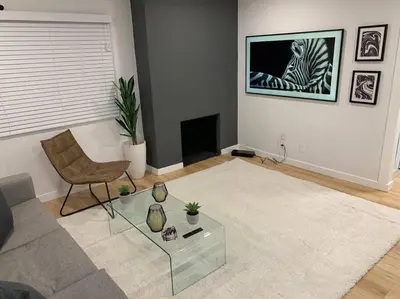 a living room with a couch and a glass table at Brand New Ocean-View Beach Home Steps to the Sand! in Manhattan Beach