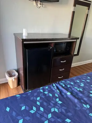 a dresser with a microwave in a bedroom at La Cienega Inn Motel in Los Angeles