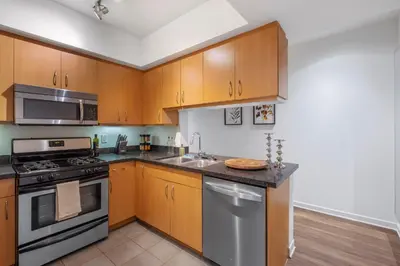 a kitchen with wooden cabinets and stainless steel appliances at 2 Santa Monica Beach Walking in Los Angeles