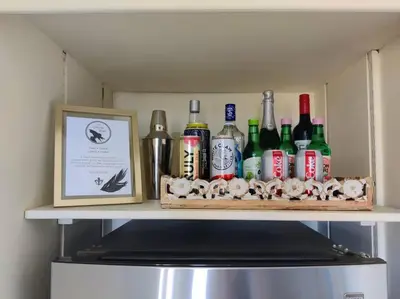 a shelf with bottles on top of a refrigerator at Epic Views! Hollywood Hills SkyVilla: Crow's Nest in Los Angeles
