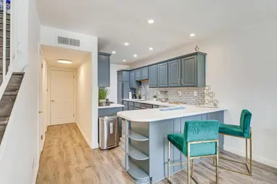 a kitchen with blue cabinets and green chairs at Los Angeles Townhome Off-Street Parking and Balcony in Los Angeles