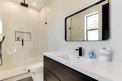 a bathroom with a sink and a toilet and a mirror at Brand New Modern 5 Bedroom House Pickfair Village in Los Angeles