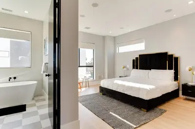 a bedroom with a large bed and a bath tub at Brand New Modern 4 Bedroom House Pickfair Village in Los Angeles