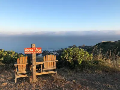 two chairs sitting next to a sign on a hill at Malibu Ranch Guest House Hideway in Malibu