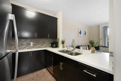 a kitchen with black cabinets and a stainless steel refrigerator at Charming & Peaceful l 1 bedroom in Marina Del Rey, CA in Los Angeles