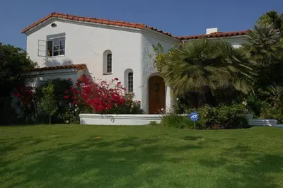 a white house with a palm tree in a yard at Beverly Hills Celebrity Home in Los Angeles