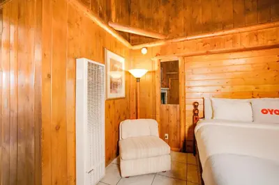 a bedroom with a bed and a chair at Arrowhead Tree Top Lodge in Lake Arrowhead