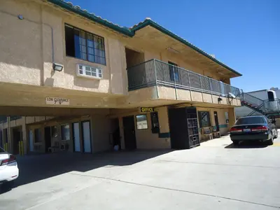 a building with a car parked in front of it at Economy Inn in Victorville