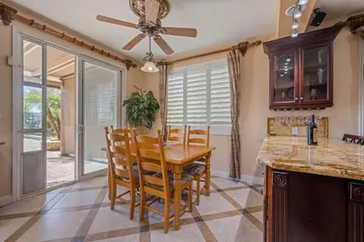 a kitchen with a table and chairs and a ceiling fan at ৎ୭The safty paradiseৎ୭ H/w Pool Jacuzzi &much more in Los Angeles