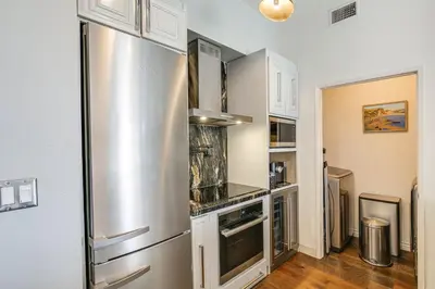 a kitchen with a large stainless steel refrigerator at Luxe Long Beach Condo with Pool 1 Mi to Shoreline! in Long Beach