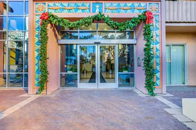 an entrance to a store with a christmasreath and a door at Luxe Long Beach Condo with Pool 1 Mi to Shoreline! in Long Beach