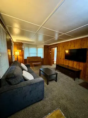 a living room with a couch and a flat screen tv at Crest Lodge Historic Mountain Inn in Crestline