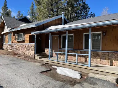 a brick house with a porch on a street at Snow Bear Lodge in Big Bear Lake