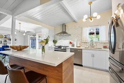 a kitchen with white cabinets and a large island at Valley Glen Getaway in Van Nuys