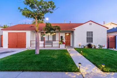 a white house with a tree in the yard at Acogedora Casa Cerca de Todo in Los Angeles