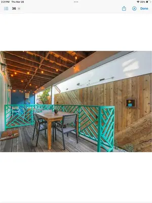 a dining area with a table and a wooden fence at Peace palace in Los Angeles