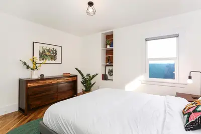a white bedroom with a bed and a window at Peace palace in Los Angeles