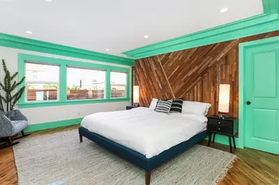 a bedroom with a large bed and two windows at Peace palace in Los Angeles