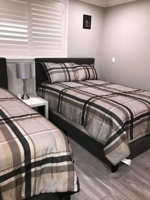 a bedroom with two beds and a lamp on a table at New! Modern Gated Summer Getaway Home in Rosemead
