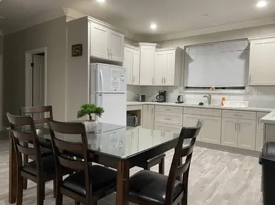 a kitchen with a glass table and chairs in it at New! Modern Gated Summer Getaway Home in Rosemead