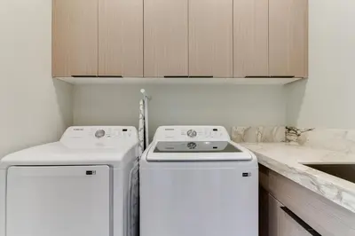 a kitchen with two white washers and a sink at Brand New Modern 9 Bedroom Compound in Pickfair Village in Los Angeles