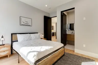 a bedroom with a large bed and a bathroom at Brand New Modern 9 Bedroom Compound in Pickfair Village in Los Angeles