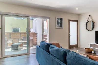 a living room with a blue couch and a sliding glass door at Redondo Beach 2br walk to shops restaurants LAX-1166 in Torrance