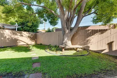a bench sitting under a tree next to a fence at 1 Mi to Shopping and Dining Central Burbank Duplex in Burbank
