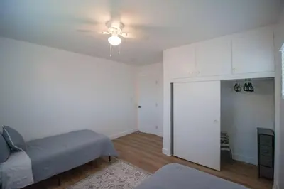 a living room with a bed and a ceiling fan at Comfortable & Modern 3BD/2BA Home -pet friendly! in Lawndale