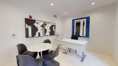a white desk and chairs in a room with paintings at Luxe MDR apartment,Parking, Gym, Pool, jacuzzi,BBQ in Los Angeles