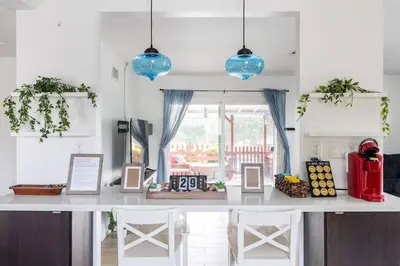 a kitchen with a counter with chairs and blue lights at Private Pool Retreat Near Disney Game Room & Firepit in Fullerton