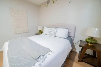 a bedroom with a large white bed with two lamps at Spacious Disney Retreat with Pool Table Fire Pit in Placentia