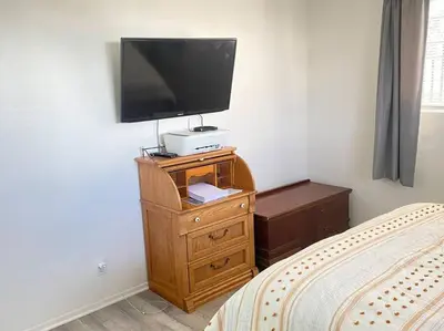 a bedroom with a tv on a wooden dresser at Sea View, Boards, Bikes, W/d in Oxnard