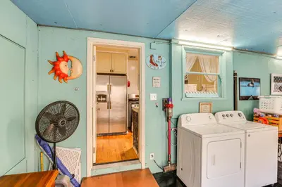 a laundry room with a washing machine and a fan at Gardena Vacation Rental 5 Mi to Manhattan Beach! in Gardena