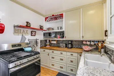 a kitchen with white cabinets and a stove and a sink at Gardena Vacation Rental 5 Mi to Manhattan Beach! in Gardena
