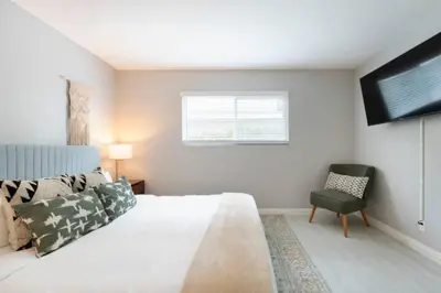 a bedroom with a bed and a chair and a television at 5 Mins to DT Alhambra - Homey 2BR Apt 4A in Alhambra