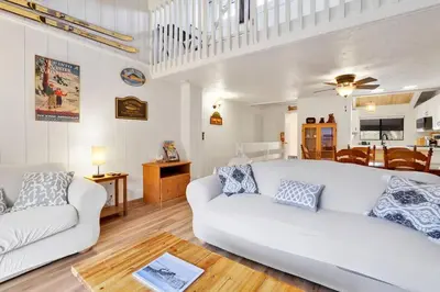 a living room with two white couches and a kitchen at Chairlift Lodge Bg Bear~ Walk to Lift Condo~ in Big Bear Lake