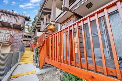 a house with a wooden fence in front of it at Chairlift Lodge Bg Bear~ Walk to Lift Condo~ in Big Bear Lake