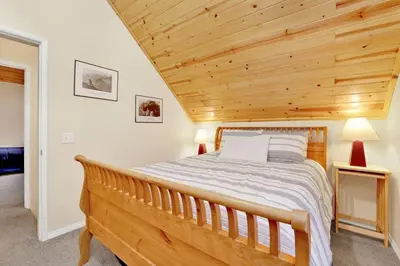 a bedroom with a wooden ceiling with a bed at Mount Berkley Big Bear~ Walk to Village~ Games~ in Big Bear Lake
