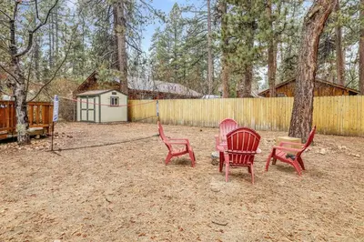three red chairs sitting in a yard next to a tree at Timber Pines Chalet~ Hot Tub~ Walk to Lake/Marina~ in Big Bear Lake