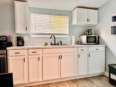 a kitchen with white cabinets and a sink and a microwave at Walk To Americana on Brand. in Glendale
