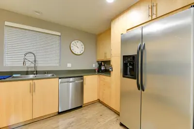 a kitchen with a refrigerator and a clock on the wall at Wake Up to Spectacular Marina Views in this 2 Bedroom Condo in Los Angeles