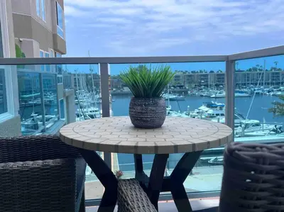 a patio table with a potted plant on a balcony at Wake Up to Spectacular Marina Views in this 2 Bedroom Condo in Los Angeles