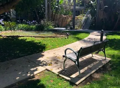 a park bench sitting on a sidewalk in the grass at Marina Life: Smell the Sea, Feel the Breeze in Los Angeles